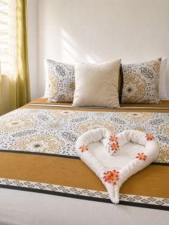 A bright guest room with floral linens at Cattleya Flor Hotel